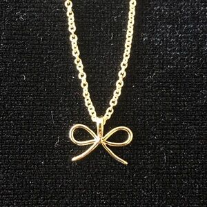 Gold colored metal bow necklace/pendant.